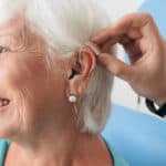 Colocando audífono mujer mayor